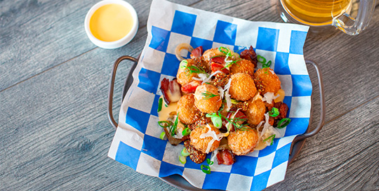 Loaded Seafood Hushpuppies with Beer Cheese, Sauerkraut, Bacon & Onions